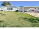 White single story home with carport and green lawn at 718 Barber Cir # 718, Lakeland, FL 33803