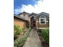 Front entrance with red door, landscaping, and walkway at 737 Butternut Pl, Lakeland, FL 33813