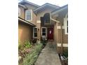 Front entrance with red door, landscaping, and walkway at 737 Butternut Pl, Lakeland, FL 33813