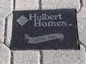 Black plaque with Hulbert Homes logo and Traditional Designs at 1898 Charleston Ln, Bartow, FL 33830