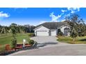 House with a three-car garage, palm trees, and well-manicured lawn at 4402 Fairway Oaks Ct, Mulberry, FL 33860