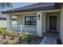 Front porch with white railing and dark brown door at 4645 Grandview Glen Dr, Auburndale, FL 33823
