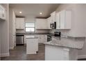 Modern kitchen with white cabinets, granite countertops, and stainless steel appliances at 5114 Villa Crest Way, Auburndale, FL 33823
