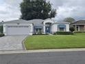 One story house with gray exterior, attached garage, and manicured lawn at 5873 Macaw Pl, Lakeland, FL 33809
