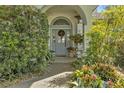 Inviting front door entry with decorative wreath and potted plants at 150 Woodcrest Ln, Mulberry, FL 33860