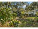 Welcoming front entrance with lush landscaping and gray door at 150 Woodcrest Ln, Mulberry, FL 33860