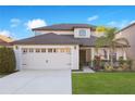 Two-story house with a two-car garage, landscaping, and a light beige exterior at 2199 Ontario Way, Lakeland, FL 33805