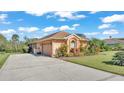Tan house with a two-car garage and nicely landscaped yard at 3206 Heron Cv, Winter Haven, FL 33884