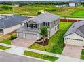 Two-story house with gray siding, tile roof, and a two-car garage in a new development at 4443 Juliana Lake Dr, Auburndale, FL 33823