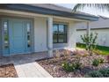 Front porch with light blue door and walkway at 5108 Villa Crest Way, Auburndale, FL 33823