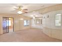 Spacious living room with carpeted floor and ceiling fans at 6683 Briarhill Ne Dr, Winter Haven, FL 33881