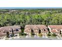 Aerial perspective of townhouses nestled in a wooded community with paved roads at 8205 Roseville, Davenport, FL 33896