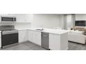 Modern kitchen with white cabinets, quartz countertops, and stainless steel appliances at 313 Wharf Way, Winter Haven, FL 33881