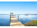 Long wooden dock extending into lake, featuring a covered seating area at 932 Van Dr, Auburndale, FL 33823