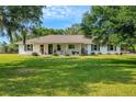 Ranch style home with white exterior and a spacious lawn at 1730 Broken Arrow N Trl, Lakeland, FL 33813