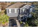 Two-story house with gray siding, dark garage door, and landscaping at 1918 Wind Meadows Dr, Bartow, FL 33830