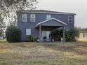 Two-story house with covered patio, grassy yard, and tropical plants at 1918 Wind Meadows Dr, Bartow, FL 33830