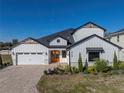 Two-story home with white siding, stone accents, and a three-car garage at 2728 Sunrise Landing Ln, Lakeland, FL 33812