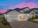 Stunning two-story home at dusk, showcasing its architectural details and landscaping at 2728 Sunrise Landing Ln, Lakeland, FL 33812