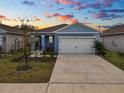 Exterior view of a charming blue home at sunset with a beautiful sky at 1754 Eagle Hammock Blvd, Eagle Lake, FL 33839