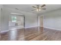Open-concept living room with wood floors and arched doorways at 217 W Lake Ave, Auburndale, FL 33823