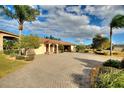 Single-story home with landscaped yard, paver driveway, and attached garage at 561 Meandering Way, Polk City, FL 33868
