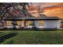 White house with a dark roof, well-manicured lawn, and sunset view at 425 E Belmar St, Lakeland, FL 33803