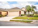 Tan house with brick garage and American flag at 7116 Lake Eaglebrooke Way, Lakeland, FL 33813