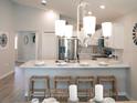 Island kitchen with white cabinets and marble countertops, overlooking dining area at 1839 Daystar Dr, Haines City, FL 33844