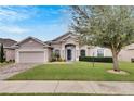 Single-story house with a two-car garage and well-manicured lawn at 332 Lake Mariana Way, Auburndale, FL 33823