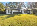 White brick ranch house with gray shutters, landscaping, and a large yard at 4409 Hallam Hill Ln, Lakeland, FL 33813