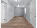 Light grey walls, wood-look flooring and bright windows in this empty bedroom at 515 S Charleston Ave, Fort Meade, FL 33841