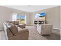Living room with L-shaped sofa, armchair, and large TV at 5460 Siltstone St, Lakeland, FL 33811