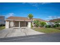 Tan two-story home with carport and landscaped yard at 4241 Oak Loop # 36, Mulberry, FL 33860