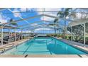 Inviting pool with screened enclosure, lake view, and grilling area at 809 Fairlane Dr, Lakeland, FL 33809