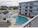 Inviting community pool with surrounding patio furniture at 3700 S Atlantic Ave # 301, New Smyrna Beach, FL 32169