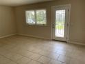 Bright living room with tiled floors, a window, and a glass door at 4513 Saxon Dr, New Smyrna Beach, FL 32169