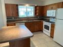 Kitchen with wood cabinets, tiled floors, and an island at 4513 Saxon Dr, New Smyrna Beach, FL 32169