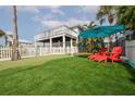 Artificial turf putting green with red chairs and umbrella at 830 Maralyn Ave, New Smyrna Beach, FL 32169