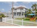 Two-story home with a white exterior, a large deck, and a putting green at 830 Maralyn Ave, New Smyrna Beach, FL 32169