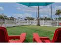 Relaxing putting green area with red chairs and umbrella at 830 Maralyn Ave, New Smyrna Beach, FL 32169