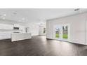 Open-concept living space with dark wood floors and kitchen island at 402 Oliver Dr, New Smyrna Beach, FL 32168