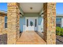 Front entry with stone columns and a white door with glass accents at 756 Bay Dr, New Smyrna Beach, FL 32168