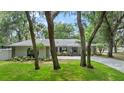 One-story home with gray roof, paver driveway, and landscaping at 1328 Needle Palm Dr, Edgewater, FL 32132