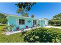 Light blue house with white trim, landscaped yard, and palm trees at 632 Goodwin Ave, New Smyrna Beach, FL 32169