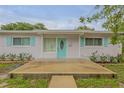 Inviting front porch with teal door and landscaping at 801 E 24Th Ave, New Smyrna Beach, FL 32169