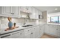 Modern kitchen with white cabinets, quartz countertops, and stainless steel appliances at 2401 S Atlantic Ave # D304, New Smyrna Beach, FL 32169