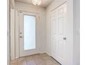 Bright entryway with tile flooring, frosted glass door, and built-in storage at 521 Mount Olympus Blvd, New Smyrna Beach, FL 32168