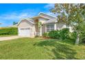Tan house with white garage door, nicely landscaped front yard at 51 Sun Dunes Cir, Ponce Inlet, FL 32127