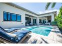 Inviting pool area with lounge chairs and outdoor kitchen at 113 Via Benevento, New Smyrna Beach, FL 32169